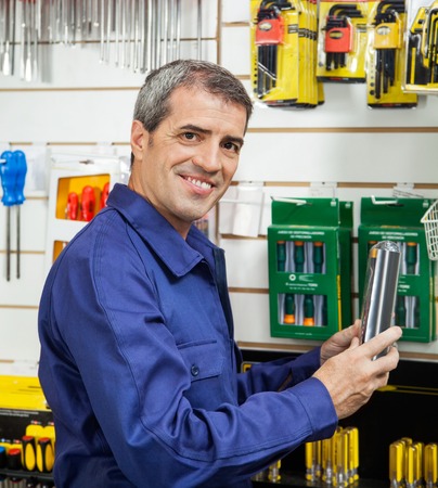 Worker Holding Packed Product In Hardware Storeの写真素材