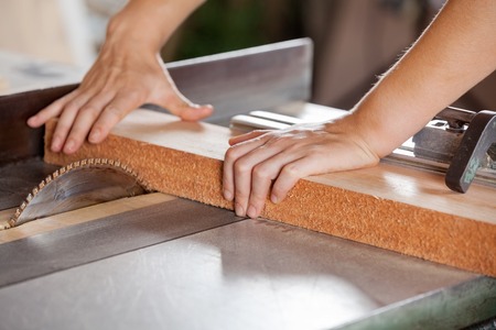 Carpenter\'s Hands Cutting Wood With Tablesaw