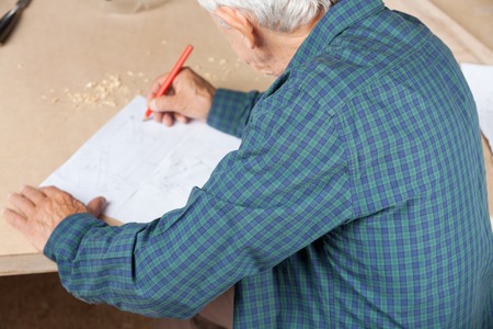 Senior Architect Working On Blueprint At Tableの写真素材