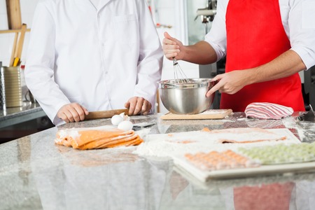 Male Chefs Preparing Ravioli Pasta At Counterの写真素材