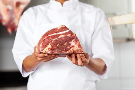 Midsection Of Butcher Holding Meatの写真素材