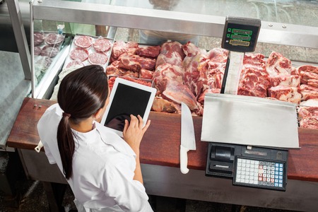 Butcher Using Digital Tablet In Butcheryの写真素材