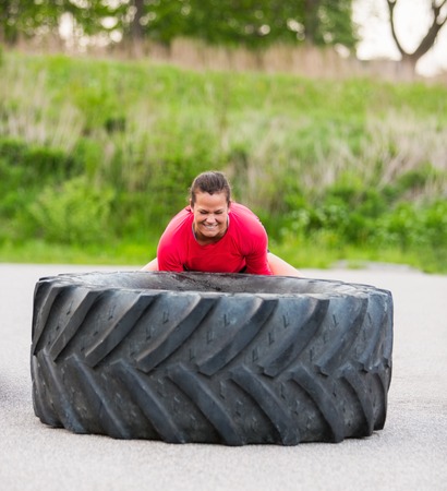 Dedicated Woman Lifting Tireの写真素材