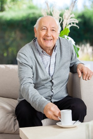 Happy Senior Man Having Coffee At Nursing Home Porchの写真素材