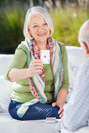 Smiling Senior Woman Playing Cards With Manの写真素材