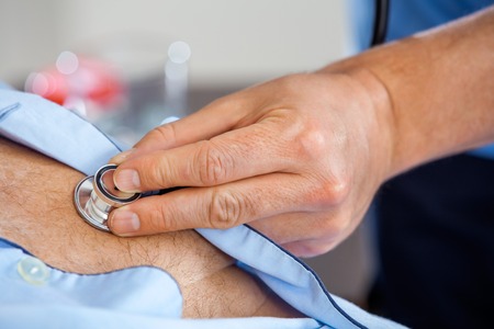 Closeup Of Caretaker Examining Senior Mans Chest