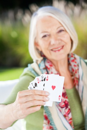 Happy Senior Woman Showing Playing Cardsの写真素材