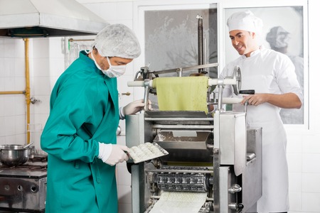 Chefs Preparing Ravioli Pasta In Machineの写真素材