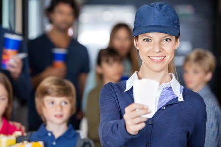 Worker Holding Tickets While Families Waiting In Background At Cの写真素材