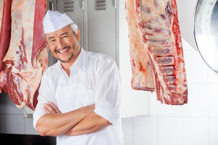 Happy Butcher With Arms Crossed In Slaughterhouseの写真素材