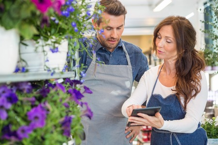 Male and female florists using digital tablet in flower shopの写真素材
