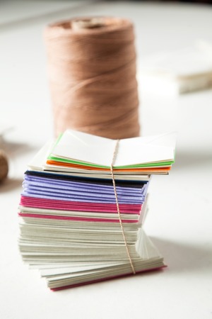 Closeup of stacked papers and thread on table in factoryの写真素材
