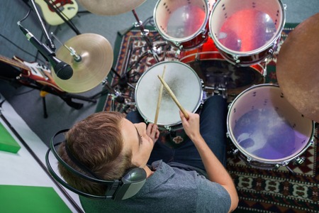 High angle view of male drummer performing in recording studioの写真素材