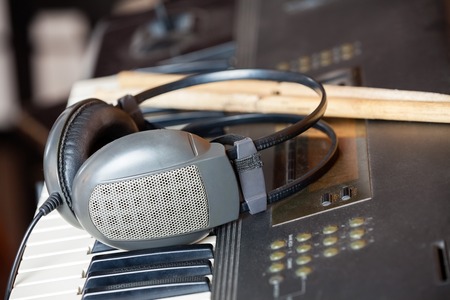 Closeup of headphones on piano in recording studioの写真素材