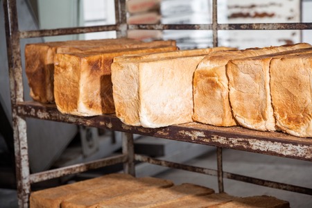Closeup of bread loaves on metallic rack in bakeryの写真素材