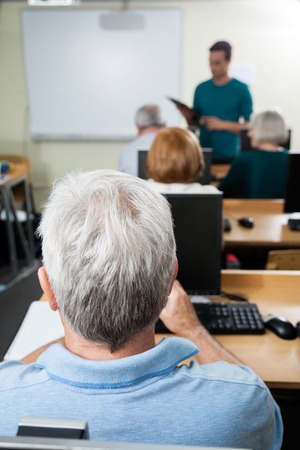 Senior student with male teacher in computer class