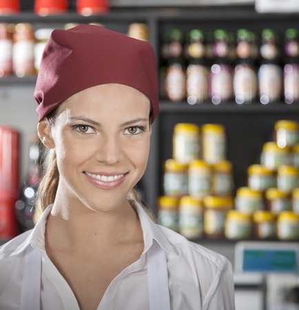 Portrait of happy young saleswoman in grocery store