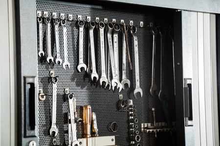 Various work tools hanging on wall at auto repair shop