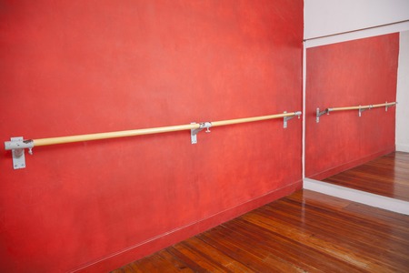 Ballet bar against red wall in rehearsal roomの写真素材