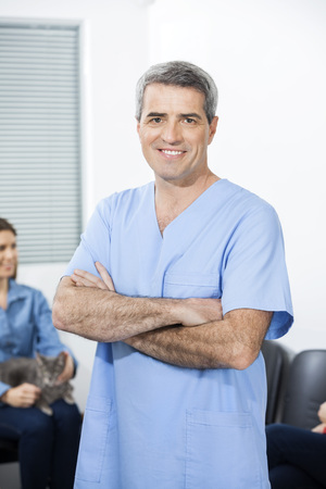 Portrait of confident male nurse with arms crossed standing in clinicの写真素材