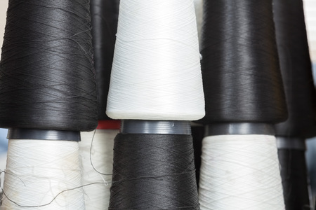 Full frame shot of black and white thread spools at sewing factoryの写真素材