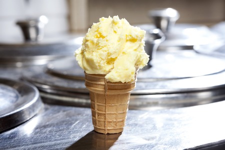 Closeup of vanilla ice cream in cone on counter at shopの写真素材