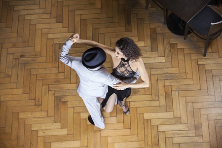 High angle view of male and female dancers performing on hardwood floor at restaurantの写真素材