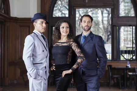 Confident welldressed tango dancers looking away while standing in restaurantの写真素材