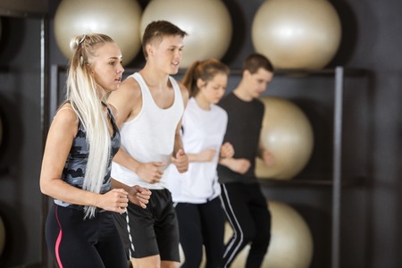 Young fit woman exercising with friends in gymの写真素材