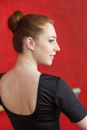 Rear view of beautiful ballerina practicing in dance studioの写真素材