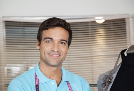 Closeup portrait of smiling male tailor at sewing factoryの写真素材