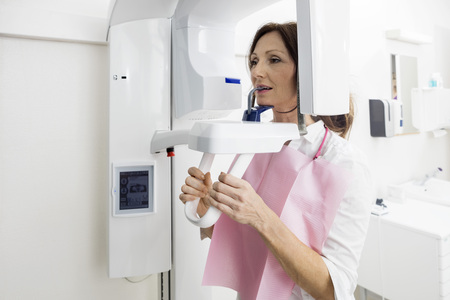 Female patient using panoramic xray machine in clinicの写真素材