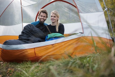 Happy Young Couple Relaxing In Tent At Forestの写真素材