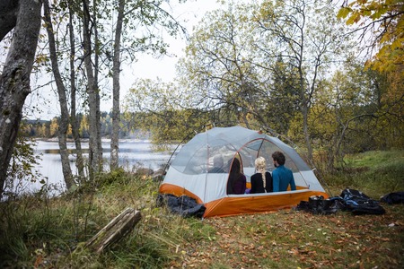 Friends Relaxing In Tent On Lakeshoreの写真素材