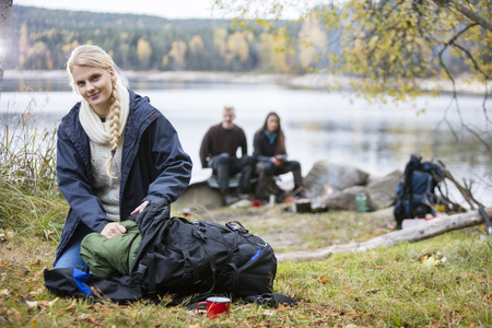 Young Woman Unpacking Backpack At Campsiteの写真素材