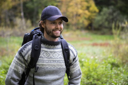 Smiling Man With Backpack Hiking In Forestの写真素材