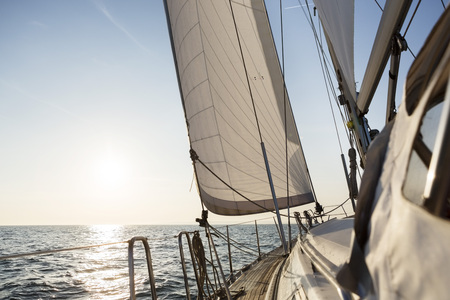 Luxury Sail Boat Sailing In Open Sea During Sunriseの写真素材
