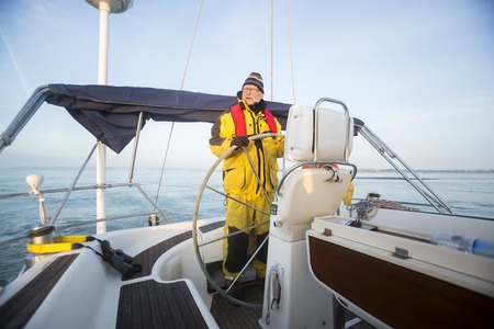 Man Steering Wheel Of Yacht In Seaの写真素材