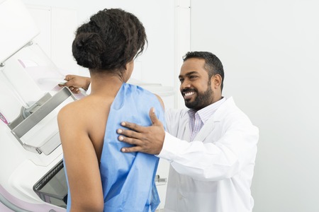 Doctor Assisting Female Patient Undergoing Mammogram X-ray Testの写真素材
