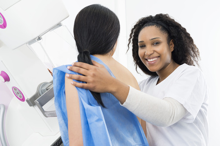 Happy Doctor Assisting Patient Undergoing Mammogram X-ray Testの写真素材