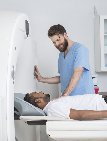 Young Doctor About To Start CT Scan On Male Patientの写真素材