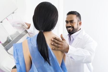 Male Doctor Assisting Woman Undergoing Mammogram X-ray Testの写真素材