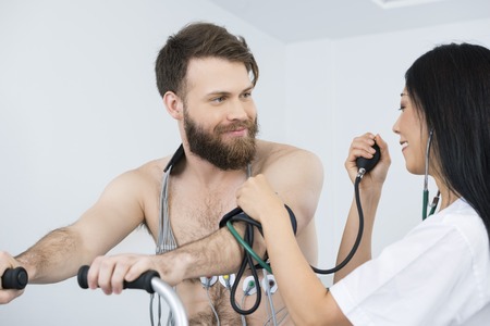 Doctor Measuring Blood Pressure Of Patient With Electrodes On Boの写真素材