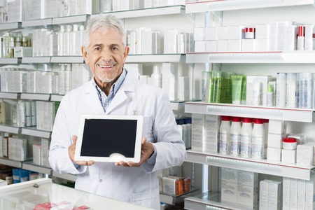 Senior Pharmacist Holding Digital Tablet With Blank Screenの写真素材