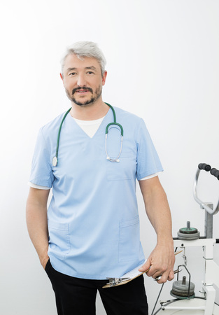 Confident Doctor Holding Clipboard In Hospitalの写真素材