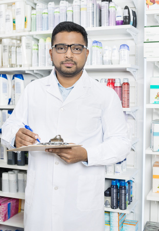 Confident Pharmacist Holding Clipboard In Pharmacyの写真素材