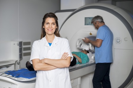 Smiling Doctor With Colleague Preparing Patient For CT Scanの写真素材