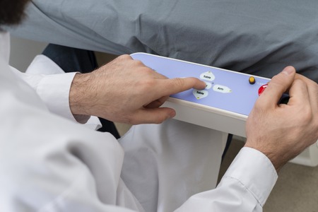 Doctor Using Control Panel Of Bed In Hospitalの写真素材