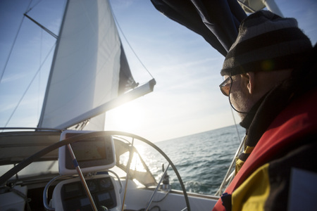Man Standing At Helm Of Yacht In Seaの写真素材