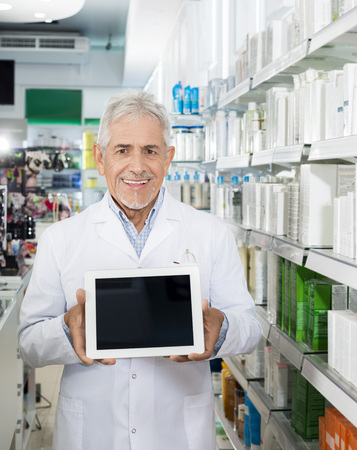 Confident Pharmacist Holding Digital Tablet With Blank Screenの写真素材